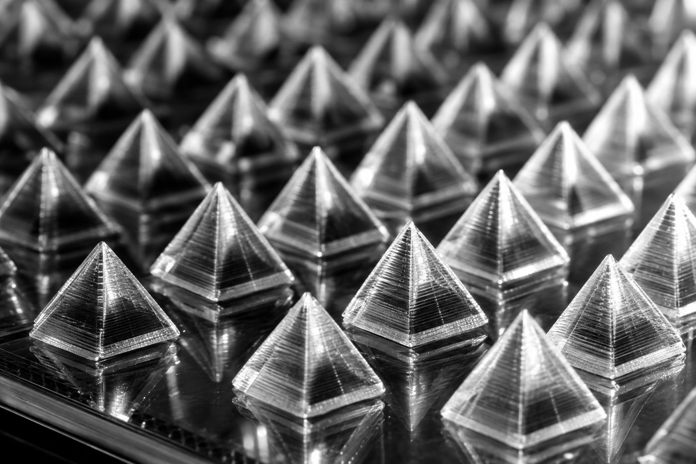 Macro view of a dense field of tiny transparent pyramids on glass